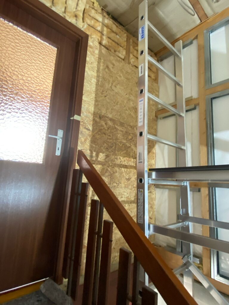 Gerüst-Einsatz während Trockenbauarbeiten an der Treppe – sichere Arbeitsplattform