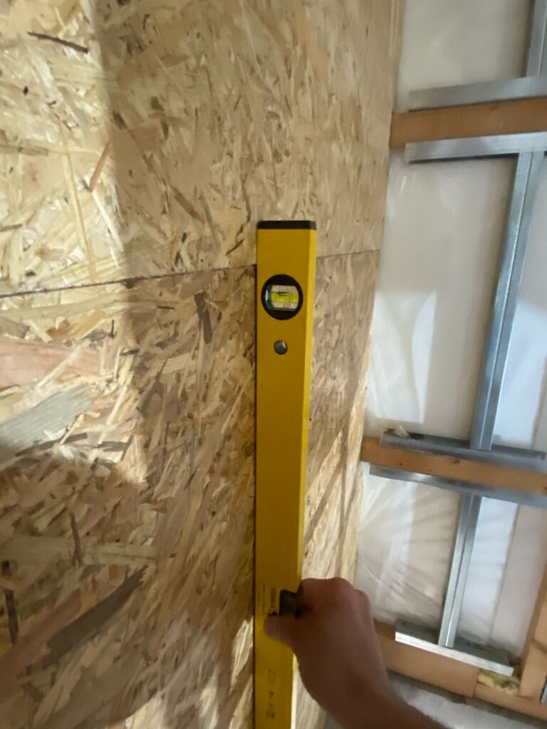 Trockenbau Projekt OSB – Kontrolle der Treppenkonstruktion mit Wasserwaage für exakte Ausrichtung